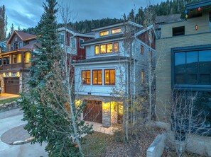 A multi-story house with a stone foundation, wooden exterior, and multiple windows. - 521 Woodside Gem True Ski-in Ski-out On The Gold Coast 3 Bedroom Home (Park City)