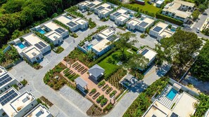 Un ensemble résidentiel comprenant plusieurs bâtiments, des panneaux solaires et un espace paysager central agrémenté d’un belvédère.