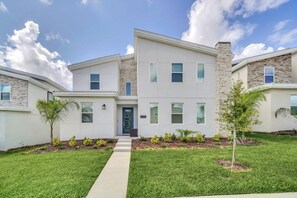 A modern two-story building with a central entrance, a small porch, and a well-maintained lawn. - Disney Princess Bedroom, Pool Spa Game Room Plus! 9 Villa (Davenport)