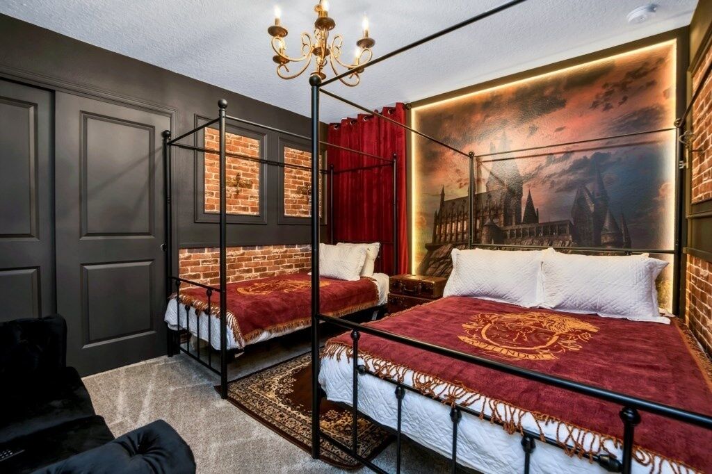 A room with a four-poster bed, a chandelier, and a mural of a city skyline.