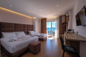 Een hotelkamer met twee bedden, een bureau, een stoel en een televisie.