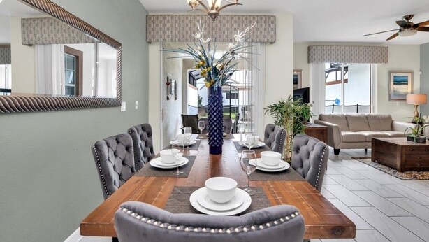 A dining area with a wooden table set for six, surrounded by upholstered chairs. - 4804crusoe 4 Bedroom Townhouse (Kissimmee)