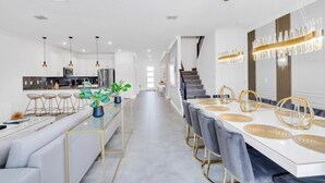 Una cocina moderna con armarios blancos, un refrigerador de acero inoxidable y un horno empotrado.