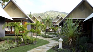 A resort with multiple bungalow-style buildings, a central pathway, and a mountainous backdrop. - Pure Magnetic Villa 10 (Nelly Bay)