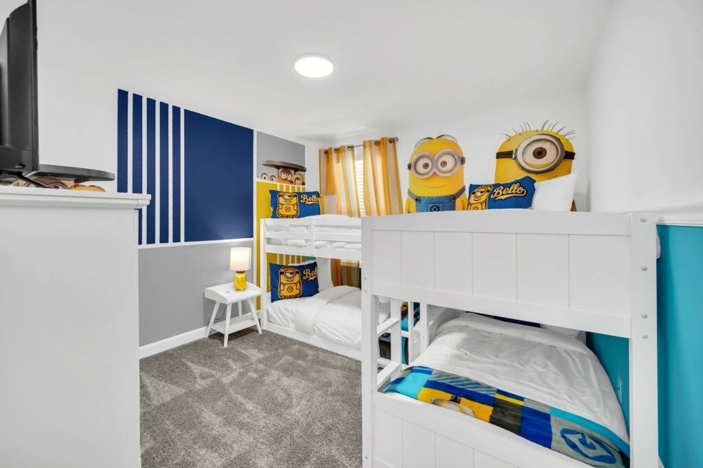 Quarto infantil com beliches, escrivaninha e decoração temática de Minions.