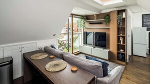 Cocina compacta con comedor, televisor integrado y un refrigerador pequeño.