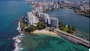 Luftaufnahme einer Küstenstadt mit Hochhäusern, einem Strand und einer Marina.