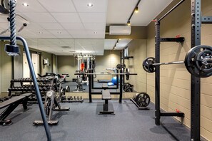Stay fit on the go with our fully equipped gym featuring a bench press, dumbbells, and squat rack.