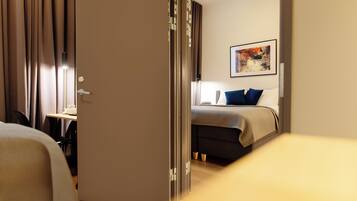 A hotel room with a bed, a desk, and a chair.