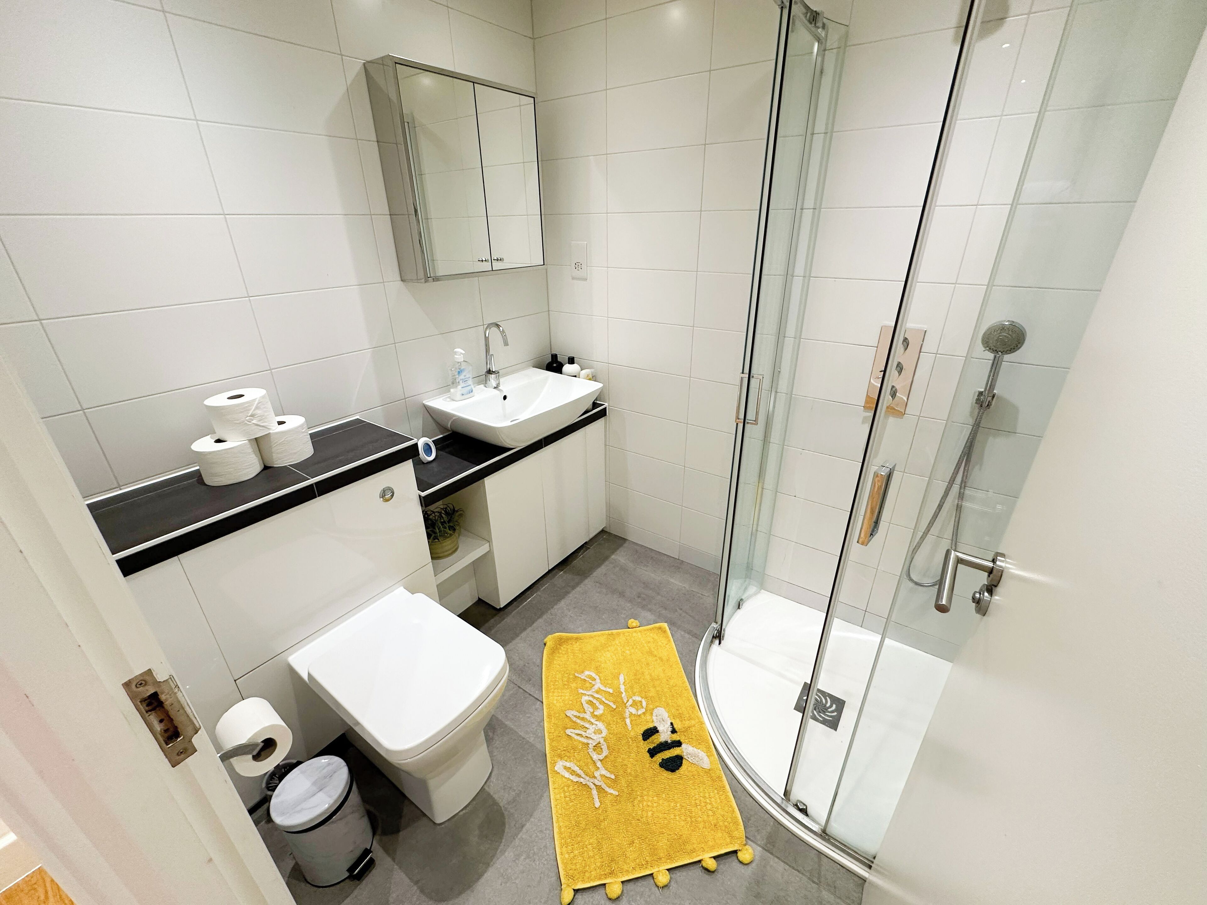 A modern bathroom with a toilet, sink, and shower.