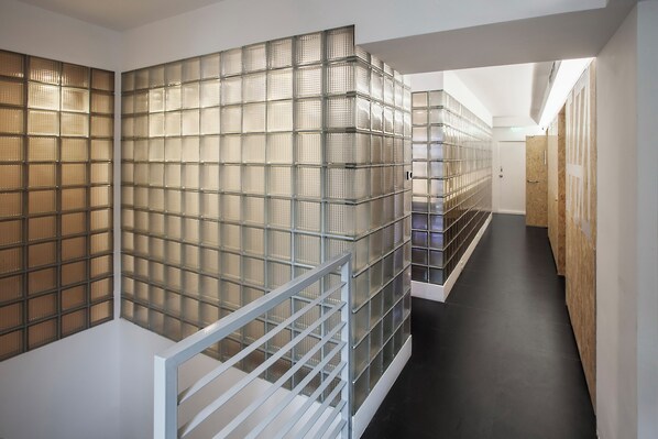 A hallway with a glass partition and a white railing. - Meow Hero Youth Hostel (Shanghai)