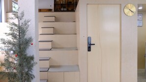 A staircase with a wooden door and a wall-mounted clock. - Meow Hero Youth Hostel (Shanghai)