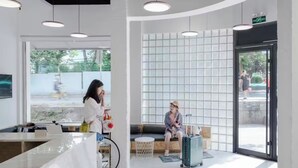 A modern hotel lobby with a reception desk, seating area, and large windows. - Meow Hero Youth Hostel (Shanghai)