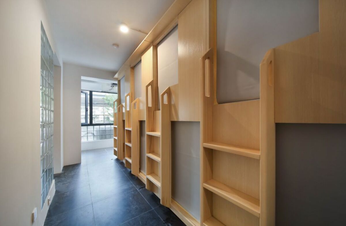 A hallway with wooden shelving units and a tiled floor.