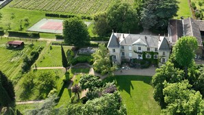 A large estate with a tennis court, landscaped gardens, and a main building with multiple windows and a roof. - Domaine de Montclair (Pommiers)