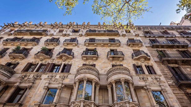 Un bâtiment historique doté de balcons richement décorés, de grandes fenêtres et de détails architecturaux classiques.