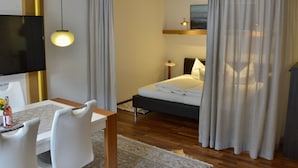 A hotel room with a bed, a desk with a chair, a TV, and curtains. - Apartment in Fulpmes Near Stubai Glacier (Fulpmes)