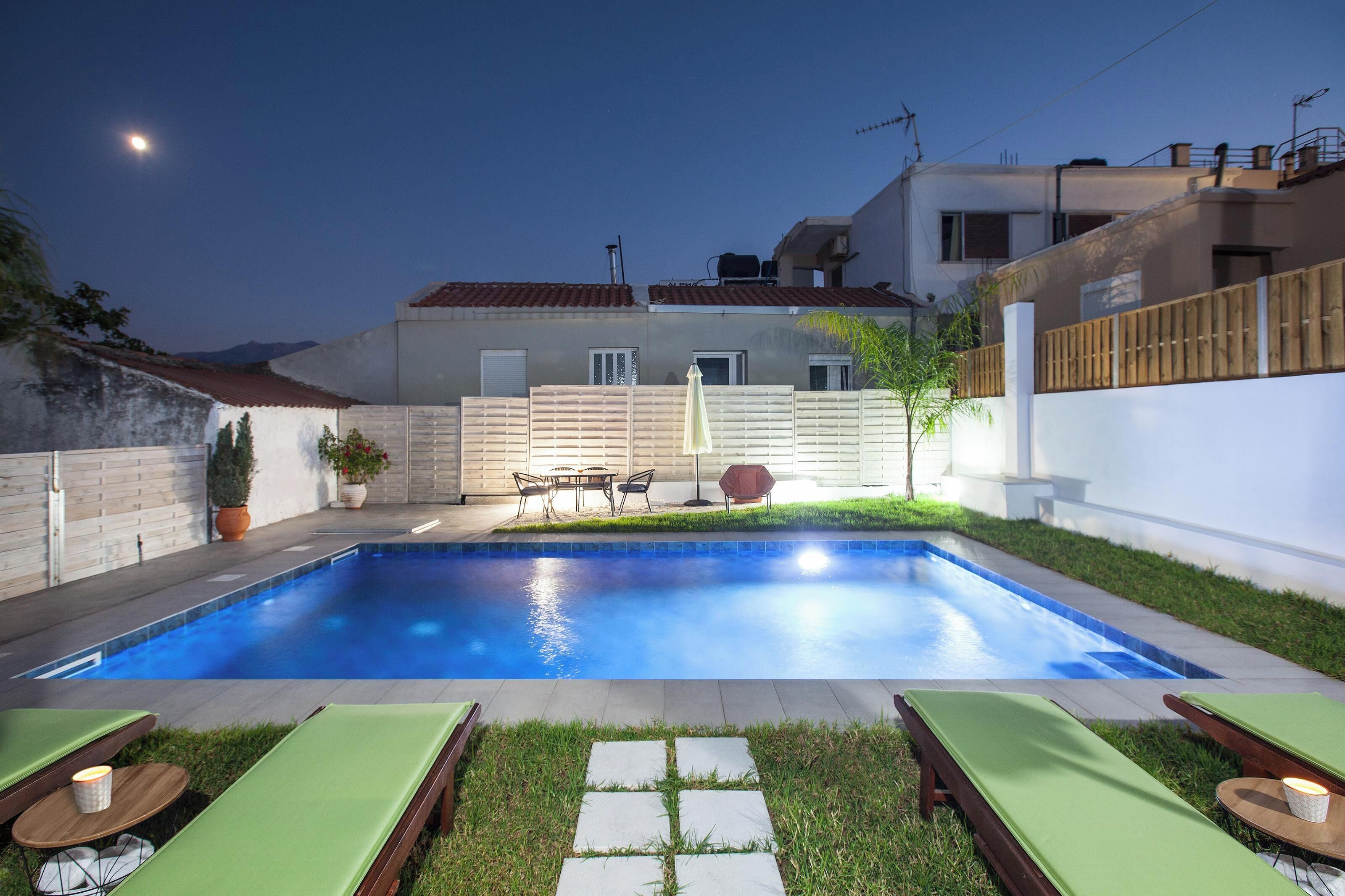 Una piscina al aire libre, sombrillas, sillones reclinables de piscina