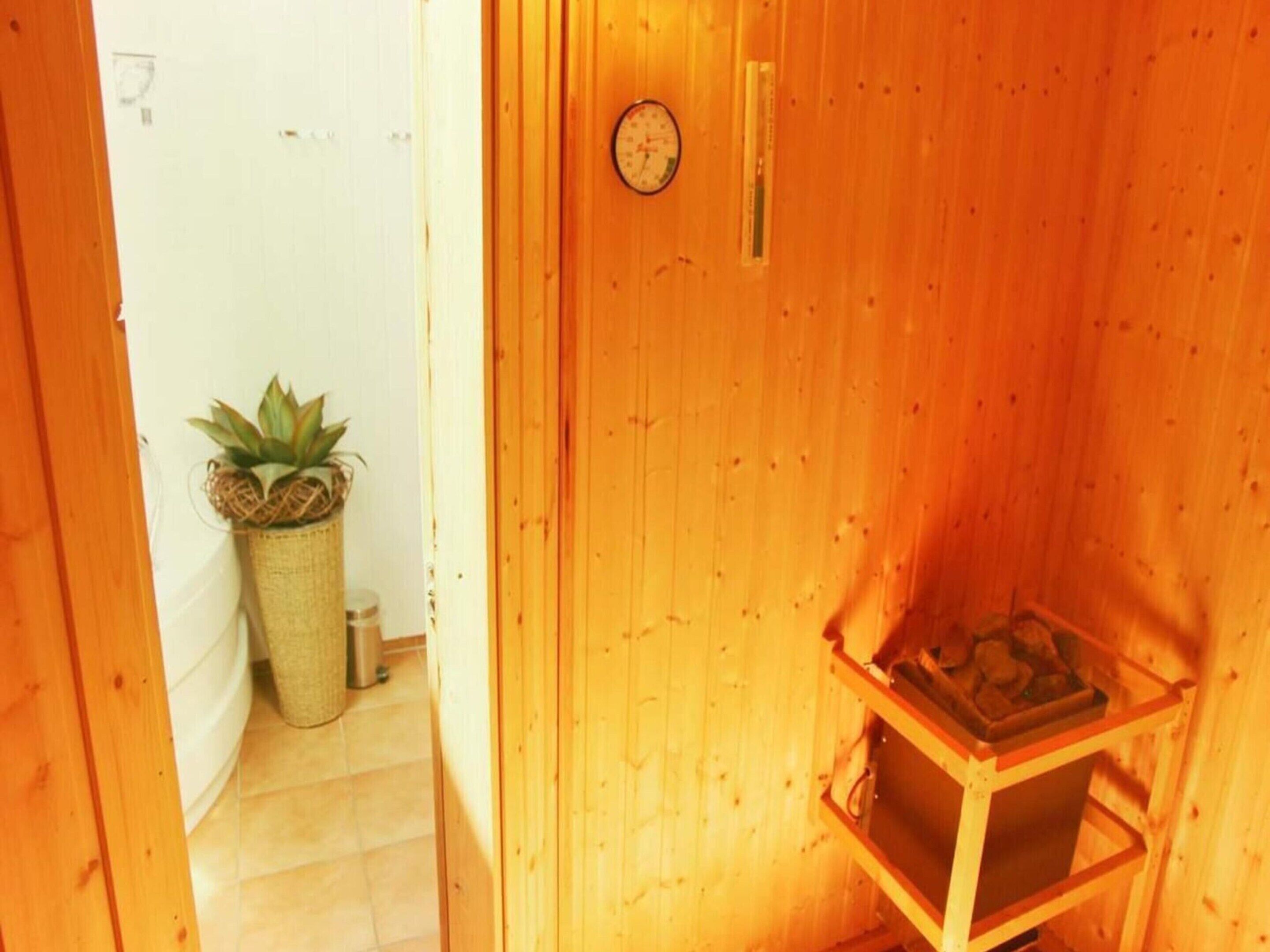 A wooden interior with a small wooden cabinet and a potted plant.