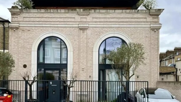 A building with two large arched windows and a brick facade. - Loftus Road (London)