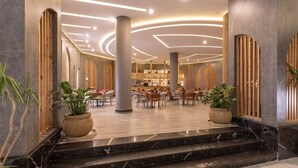A spacious lobby with marble flooring, wooden accents, and a seating area with tables and chairs. - Hurghada Long Beach Resort (Hurghada)