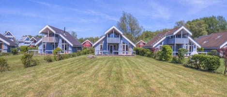 A row of blue houses with a well-maintained lawn in front.