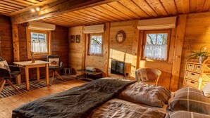 Une chambre confortable dans un chalet en rondins, avec un lit, un bureau et une chaise.