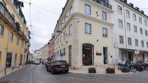 Vista de una calle con un tranvía, coches estacionados y un edificio con el letrero 'Conceptica'.