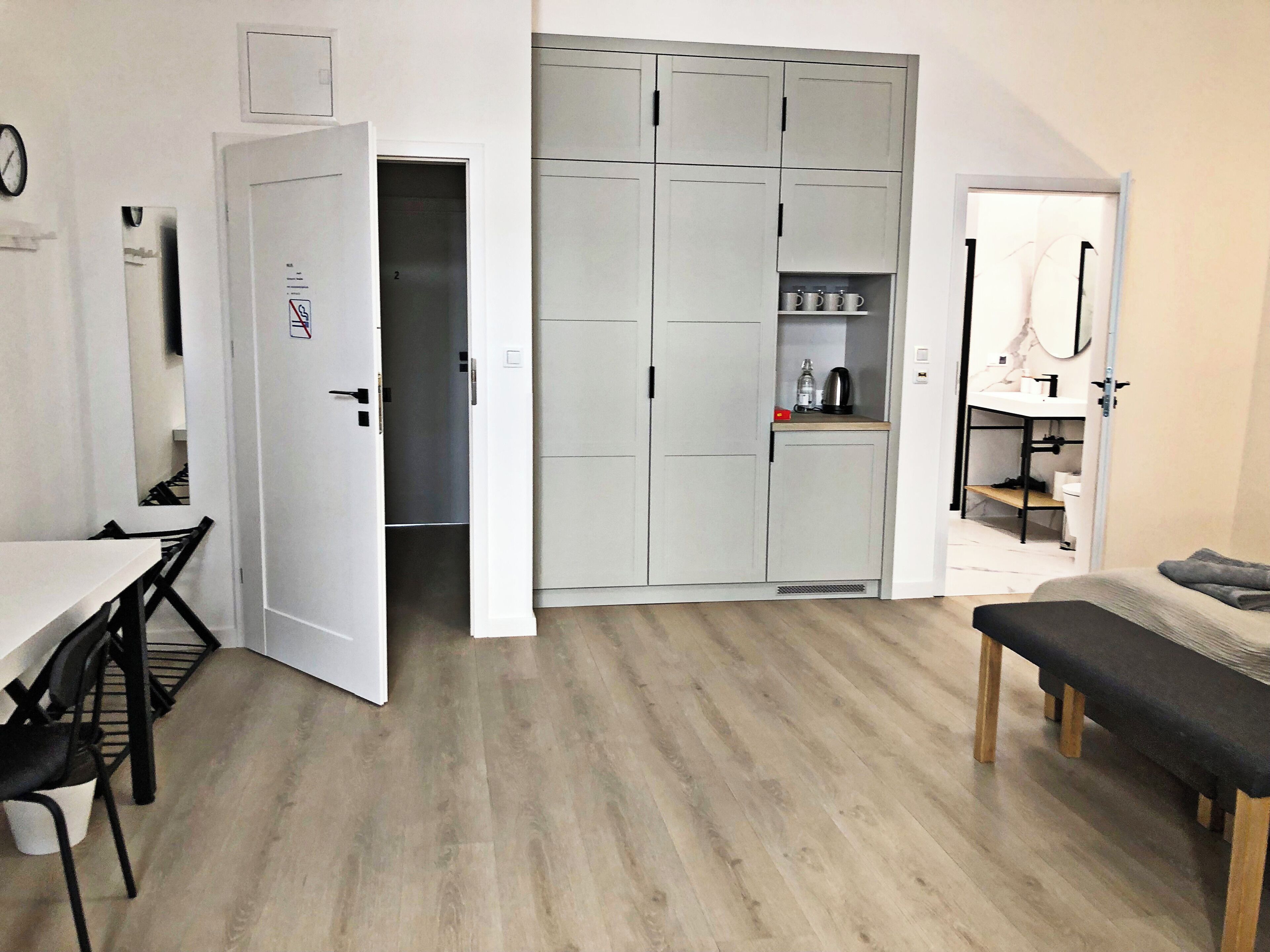 Une pièce de taille réduite comprenant un coin repas, une kitchenette et un lit.