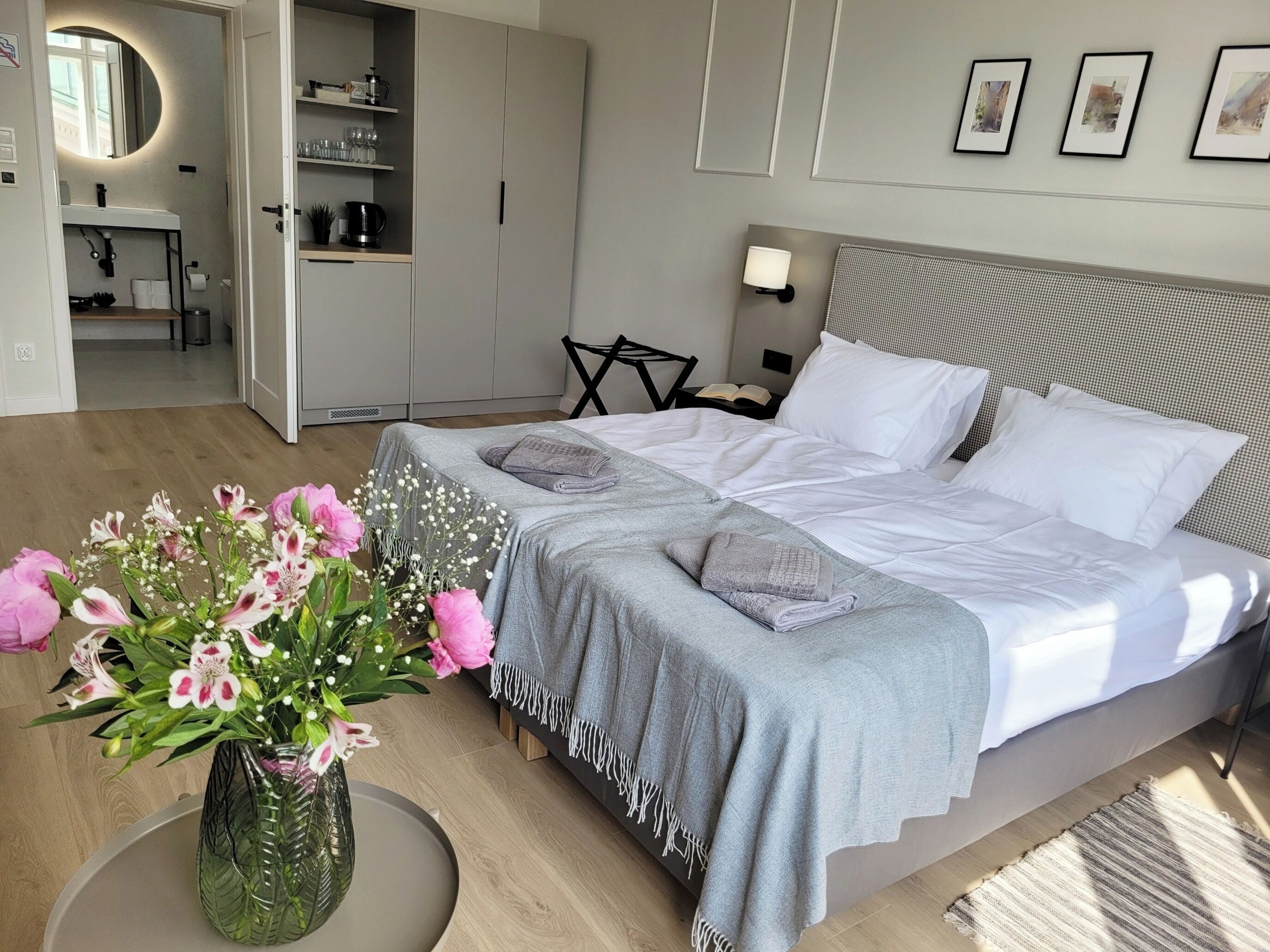 Ein modernes Schlafzimmer mit einem großen Bett, Nachttischen, einem Schminktisch und einem Kleiderschrank.