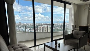 Una sala de estar moderna con un ventanal grande, un sofá, una mesa de centro y una silla.