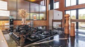 A modern kitchen with a central island, a coffee machine, and a vase with dried flowers. - Chic Retreat in Sjaellands Odde - By Traum Ferienwohnungen (Sjællands Odde)