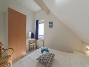 A bedroom with a bed, a desk, a chair, and a wardrobe. - Nice Holiday Home Near Beach (Wemeldinge)