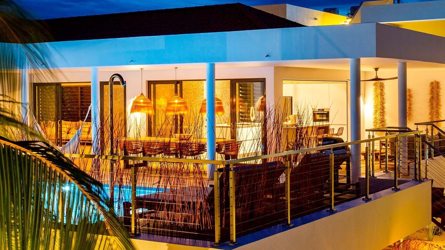 Une maison moderne dotée d’une piscine, d’un espace salon extérieur et d’un escalier.