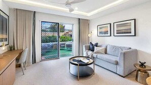 Un salon moderne comprenant un canapé, une table basse et un bureau avec une chaise.