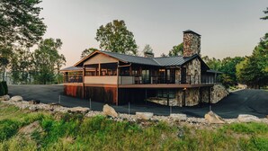 A two-story stone building with a balcony and a stone chimney. - Spacious lakeview lodge on Lake Cumberland with WiFi, AC (Seventy Six)
