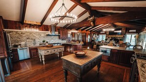 A spacious kitchen with wooden floors, a large island, and a stone backsplash. - Spacious lakeview lodge on Lake Cumberland with WiFi, AC (Seventy Six)