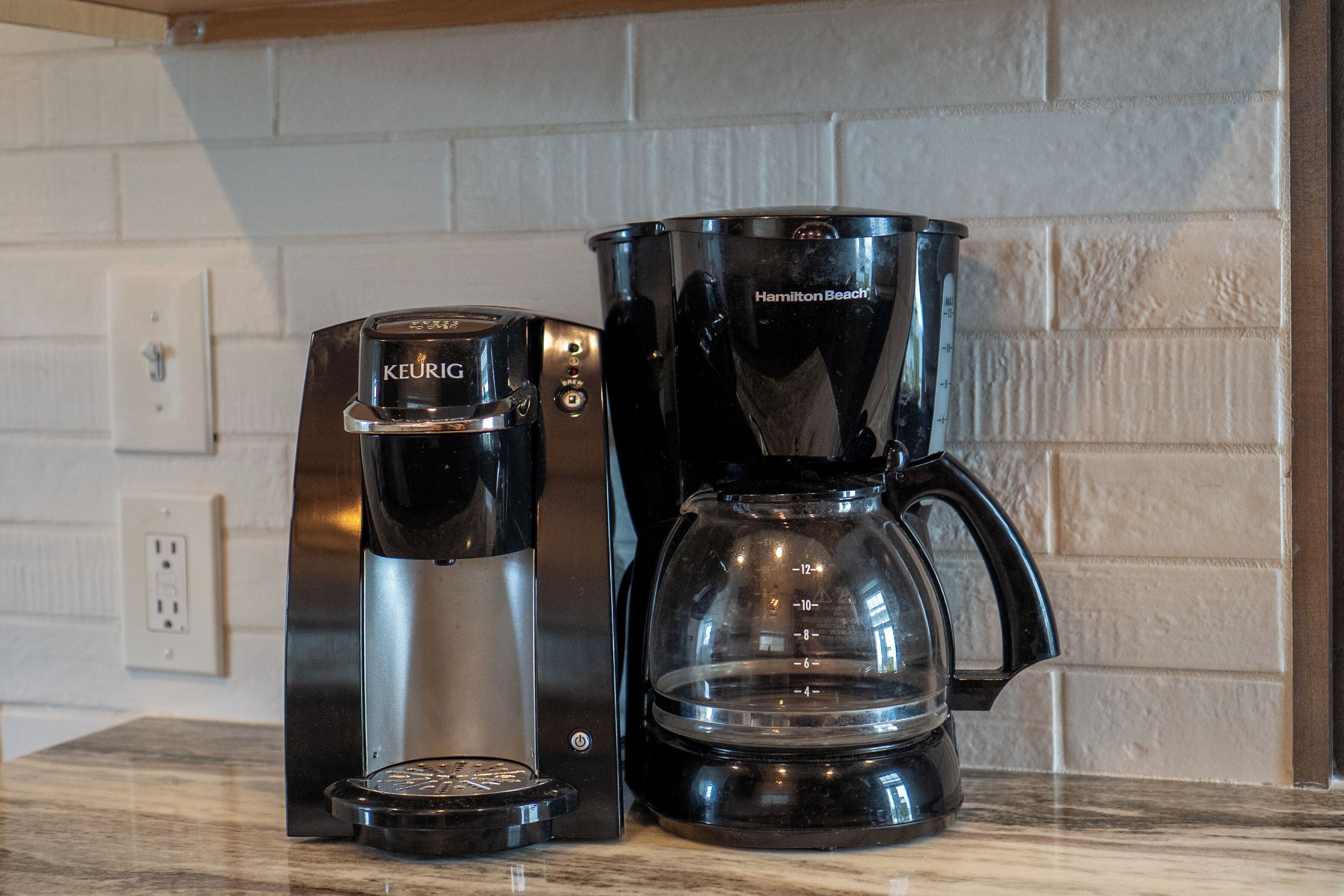 Eine Kaffeemaschine von Keurig und ein Kaffeekocher von Hamilton Beach stehen auf einer Küchenarbeitsfläche.