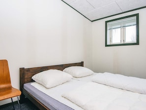 A single bed with white bedding in a room with white walls and a window with blinds. - 4 Star Holiday Home in Hovborg (Hovborg)