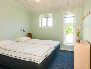 A bedroom with a bed, two windows, a desk, a chair, and a lamp. - 4 Star Holiday Home in Hovborg (Hovborg)