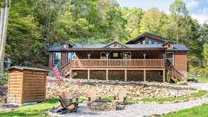 A cabin with a wooden exterior, a deck, and a stone fire pit. - 🔥 Tennessee Dream | Cozy Retreat with Fire Pit + Mortal Kombat Arcade🌲 (Sevierville)