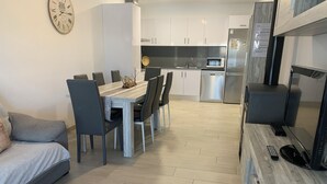 A modern living room with a sofa, dining table, chairs, and a TV. - Riumar Nature 38, villa at 100 meters from the beach in the urbanization of Riumar.  (Riumar)