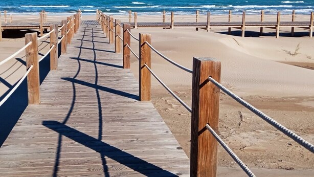 A wooden boardwalk leading to a beach with a clear view of the ocean. - Riumar Nature 38, villa at 100 meters from the beach in the urbanization of Riumar.  (Riumar)