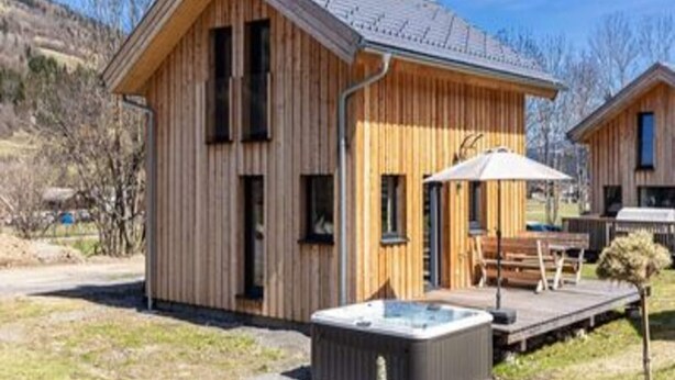 A wooden cabin with a hot tub, deck, and a clear view of the surrounding landscape. - Inviting Chalet With Terrace (Sankt Georgen am Kreischberg)
