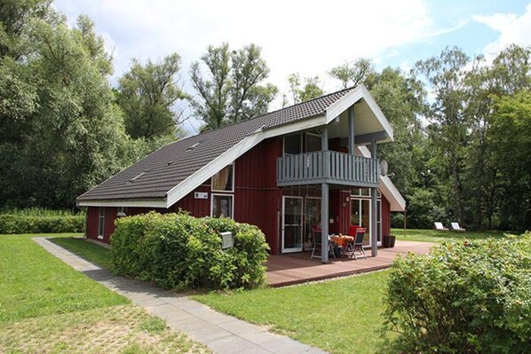 A modern house with a sloped roof, a covered porch, and a well-maintained lawn. - Ideales Ferienhaus fur Familien (Rechlin)