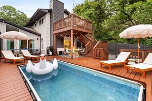 A swimming pool with lounge chairs and a swan float. - Pool, Firepit, Mins to DT, SXSW, ACL, Sleeps 8 (Austin)