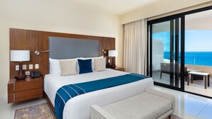 A hotel room with a large bed, a nightstand, a desk, a chair, and a balcony with a view of the ocean. - Amazing 1 bedroom condo, ocean view with AC in San José del Cabo (San José del Cabo)