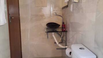 Chuveiro, toalhas de banho, papel higiênico