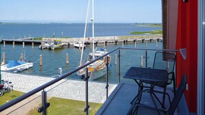Un balcón con vistas a un puerto deportivo, con barcos y un muelle.