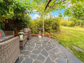 A patio area with wicker furniture, a stone floor, and a pergola with hanging lights. - Holiday Home in Allrode With Garden (Thale)